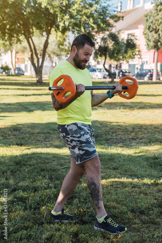 Man in sportswear lifting weights outdoor