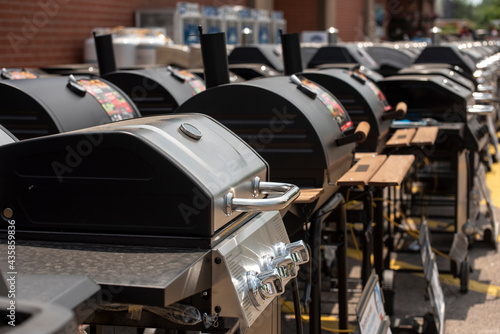 A collection of preassembled grills and smokers for sale are seen outside a retail store. 