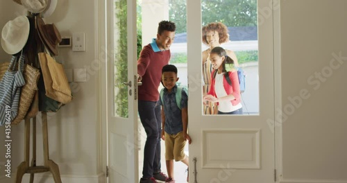 Happy african american family entering the house from front door