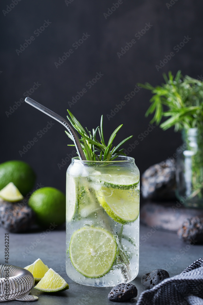 Fototapeta premium Hard seltzer cocktail with lime, rosemary and bartenders accessories