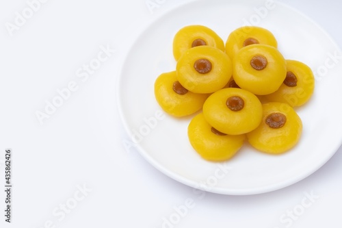 Kanom Sanay Chan, traditional sweet dessert originating in Thailand - Nutmeg –like yellow sweetmeats, serving on white plate isolated on white photo