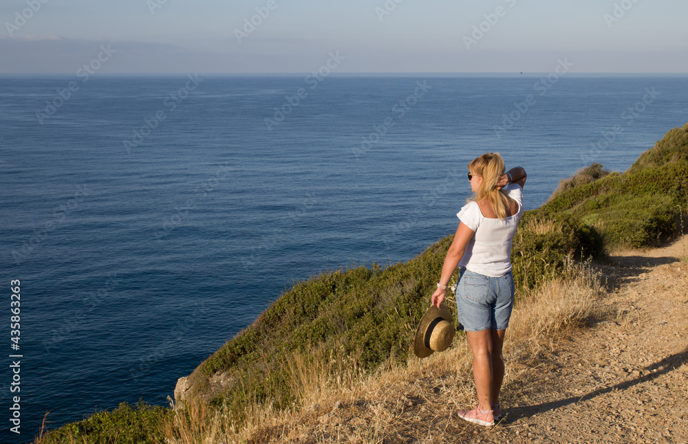 blond woman in a hat looks at the sea blond woman in a hat looks at the sea
