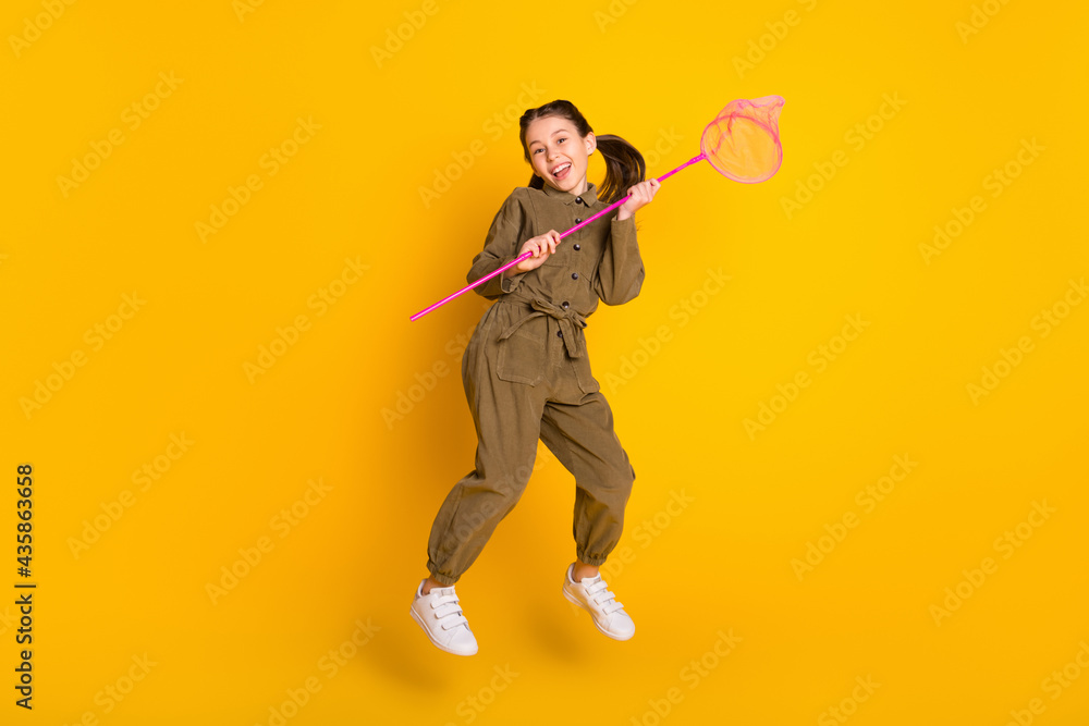 Full length portrait of active cheerful pupil jumping have good mood isolated on yellow color background Full length portrait of active cheerful pupil jumping have good mood isolated on yellow color background