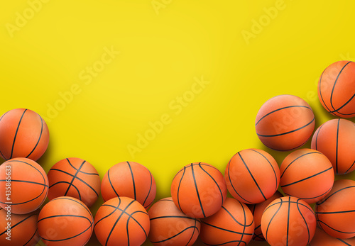 Many orange basketball balls on yellow background. Space for text