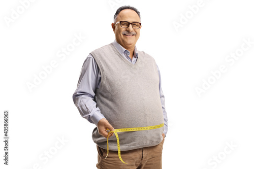 Tablou pe pânză Mature man in casual clothing measuring waist with a tape