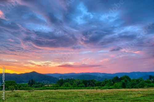 Colorful autumn sunset with sun rays coloring the clouds