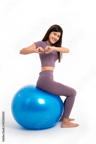 Healthy Asian woman sitting and workout on fitball on isolated white background, Concept of good health starts with exercise.