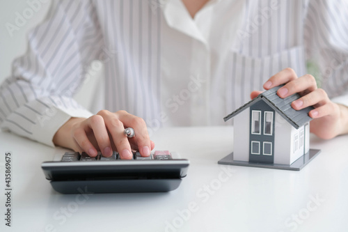 Tableau sur toile close up hand with house model for real estate check and summary expense of home loan mortgage for refinance plan, insurance or loan real estate