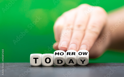 Slika na platnu Hand turns dice and changes the word today to tomorrow.