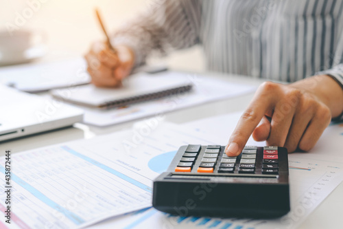woman accountant doing finance and calculate on a desk about cost at the home office. finance accounting concept