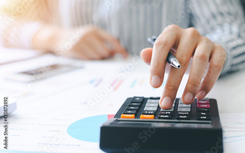 woman accountant doing finance and calculate on a desk about cost at the home office. finance accounting concept photo