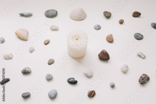 White candle and sea shells pattern on white background. Spa concept. Flat lay, top view