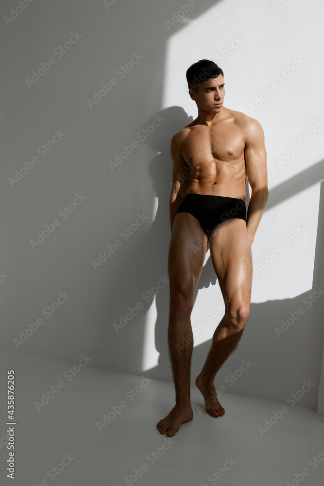 man with muscular body woman in black panties posing on light background