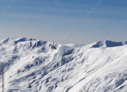 View on off-piste snowy sunlight slope at sun winter evening © BSANI