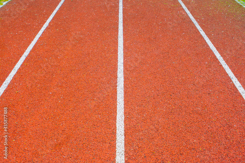White symmetrical lines of the red running track, leading to the front. Straight running track lines of the athletic field. Sport background.