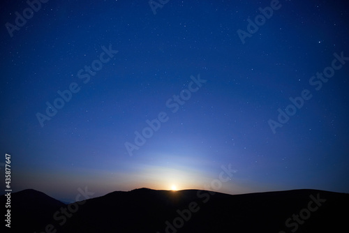 Blue dark night sky with many stars. Moon rising, night background