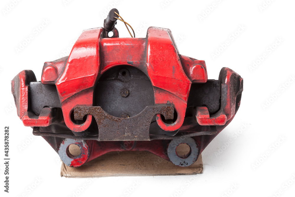 Red metal brake caliper on a white background in a photo studio for replacement during the repair of the chassis or for a catalog of spare parts for sale on auto parsing.