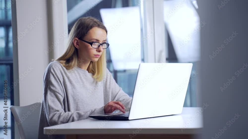 young female student working in the evening on a laptop at workplace herself. Woman freelancer alone in office or home typing front computer screen in modern room. Online learning or distance work young female student working in the evening on a laptop at workplace herself. Woman freelancer alone in office or home typing front computer screen in modern room. Online learning or distance work