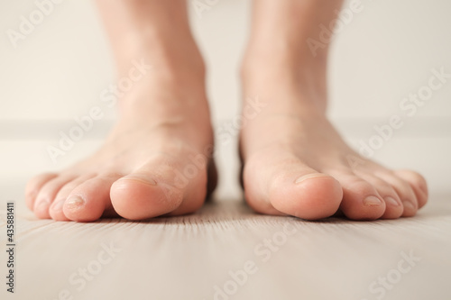 Barefoot female feet stand on the floor on a white background. Bottom view.  © koldunova