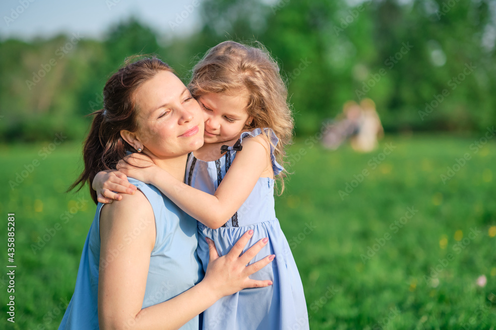Naklejka premium nature scene with family outdoor lifestyle. Mother and little daughter playing together in a park. Happy family concept. Happiness and harmony in family life.