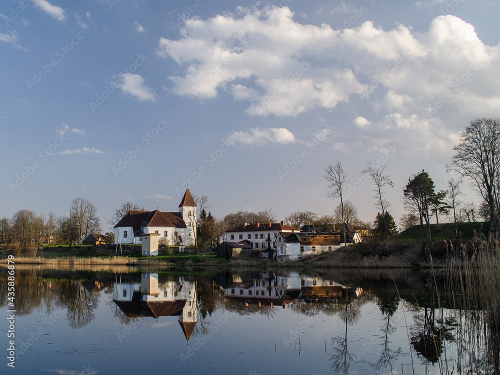 Alsunga catholic church and reflection in lake, Latvia. Alsunga catholic church and reflection in lake, Latvia.