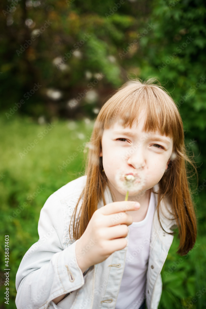 cute little girl blowing on a dandelion in a green garden cute little girl blowing on a dandelion in a green garden