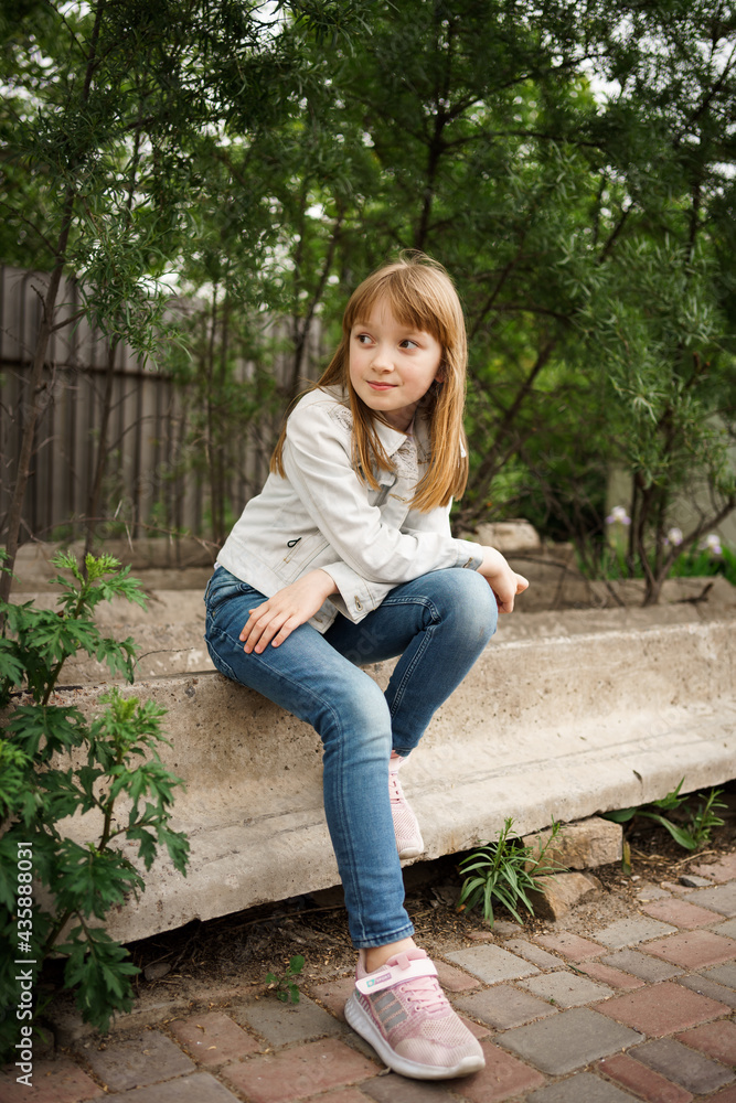 girl in a white jacket and jeans sits on the beams girl in a white jacket and jeans sits on the beams