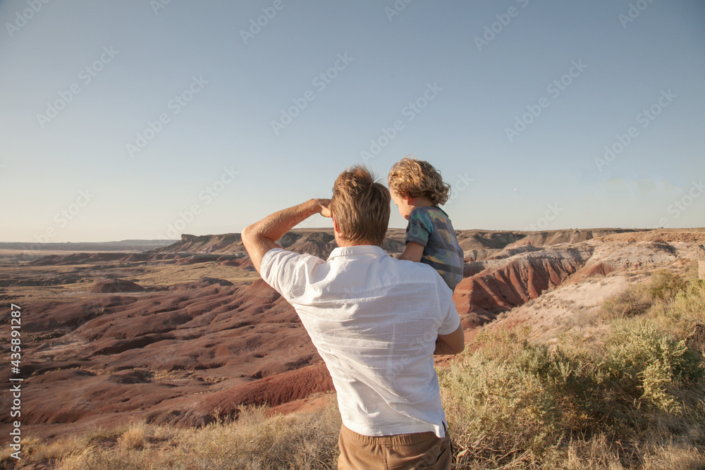 Happy family. Father and son hugging outdoors. Dad with his cute child walking outdoor Adorable curly boy hugging dad. Family Love concept. Summer vacation in American's nation parks Desert background