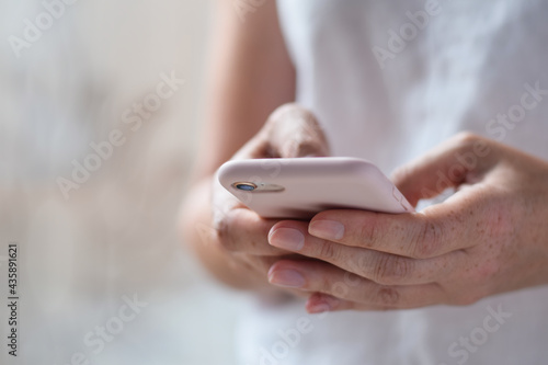 Closeup on woman's hands using mobile phone