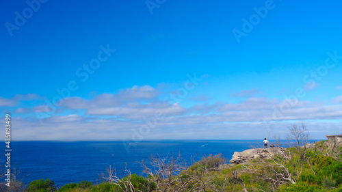 Photography Man standing in the coastline Looking out onto the vast Pacific Ocean in Sydney,