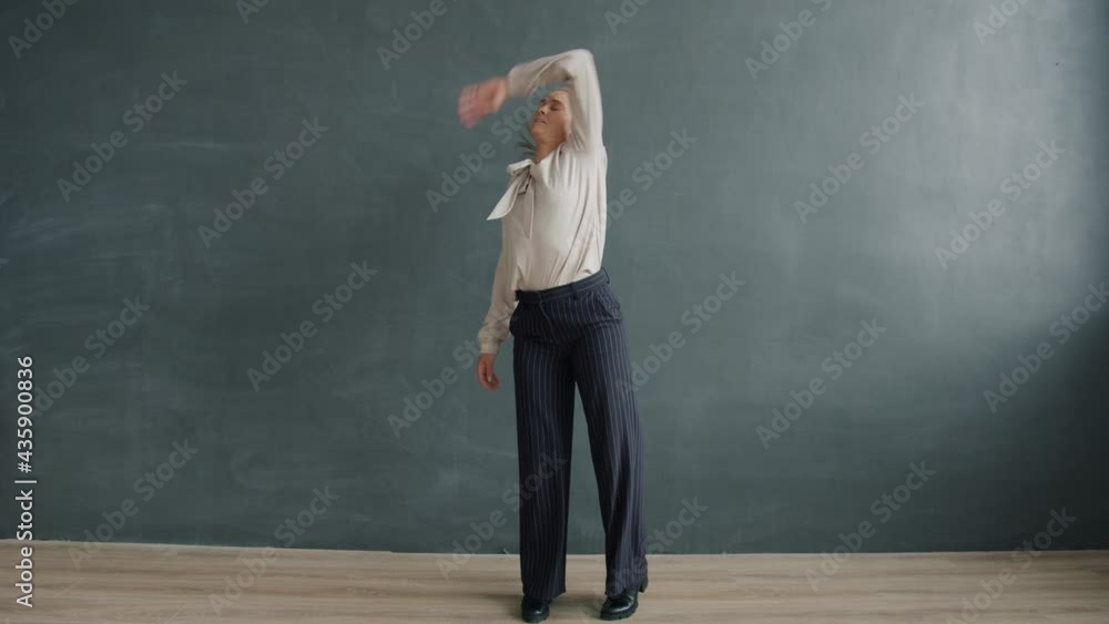 Portrait of attractive blond woman wearing elegant formal clothing dancing on black background alone having fun. Young people and positive emotions concept. Portrait of attractive blond woman wearing elegant formal clothing dancing on black background alone having fun. Young people and positive emotions concept.