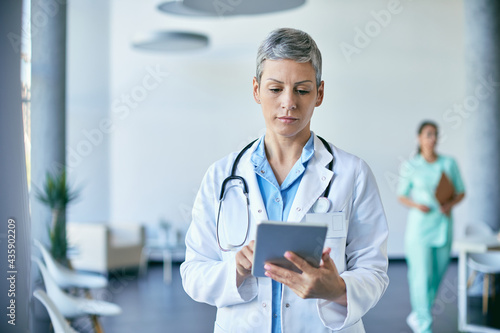 Female doctor working on digital tablet at medical clinic.