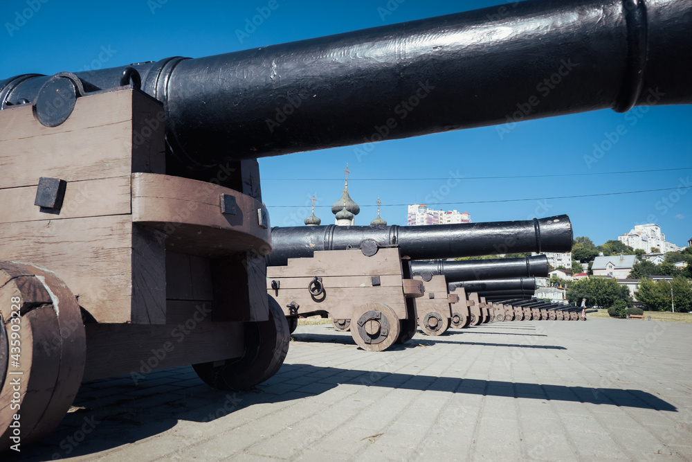 Replica cannons from battleship Goto Pristancia on Admiralteyskaya Square on clear sunny day. Behind cannons located Assumption Admiralty temple.