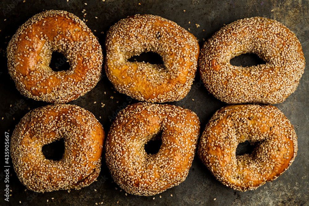 Sesame seed bagels on a dark surface