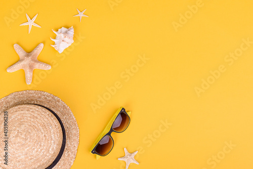 Photography Beach accessories: glasses and hat with shells and sea stars on a colored backgr