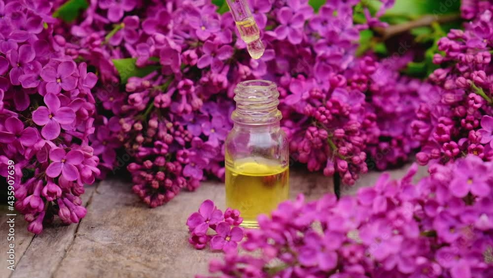 Lilac essential oil and extract in a small bottle. Selective focus. Lilac essential oil and extract in a small bottle. Selective focus.