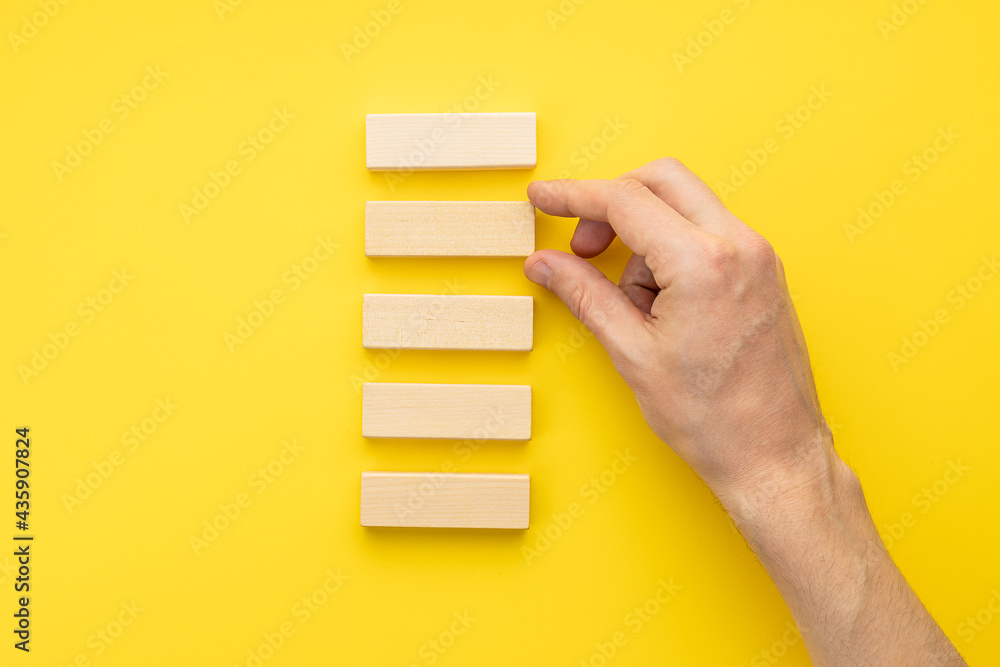 blank wooden blocks stack over yellow background. business strategy ...