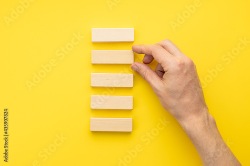 blank wooden blocks stack over yellow background. business strategy template. step notes mockup. above view