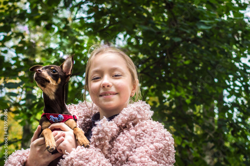 Close-up portrait of a teenage girl with a toy terrier in her arms
