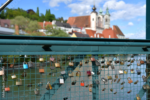 Liebesschlösser auf einem Steg in Steyr mit der Pfarrkirche Sankt Michael im Hintergrund, Österreich, Europa photo