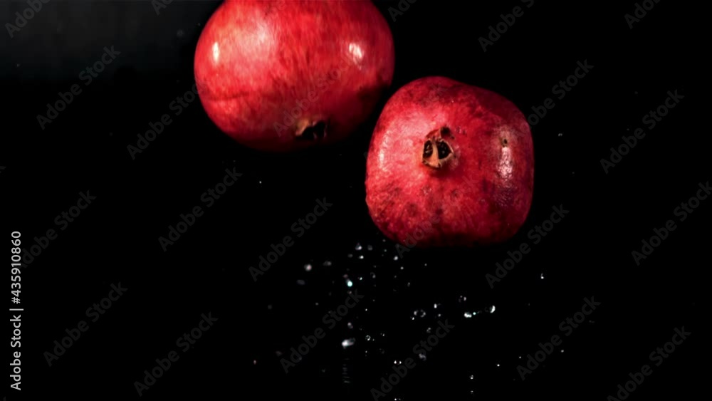 Super slow motion pomegranates fall on the table with water spray. On a black background. Filmed on a high-speed camera at 1000 fps. High quality FullHD footage Super slow motion pomegranates fall on the table with water spray. On a black background. Filmed on a high-speed camera at 1000 fps. High quality FullHD footage