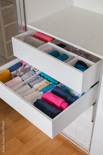 Vertical storage of clothing. Clothing folded for vertical storage in the linen drawer. Nursery. Sliding wardrobe. Room interior. Neatly folded clothes in chest of drawers.