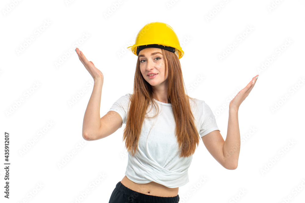 Young beautiful woman with red hair in helmet at studio