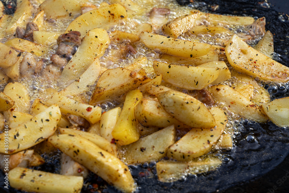 Frying large pieces of potatoes in oil Frying large pieces of potatoes in oil
