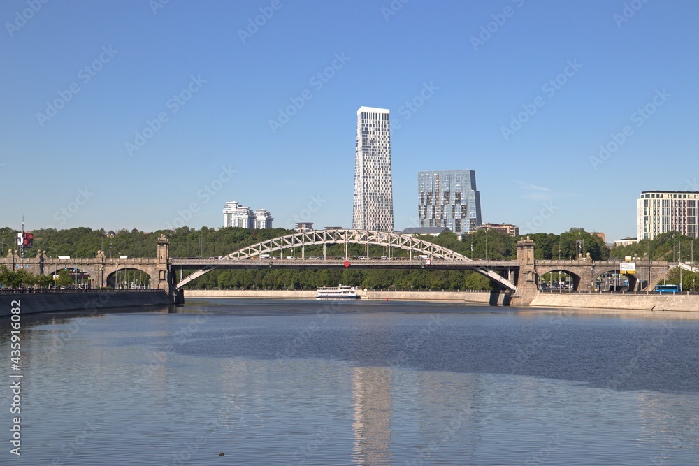 Moscow River, panoramic view of the automobile bridge. On the background of a high-rise building and a blue sky.