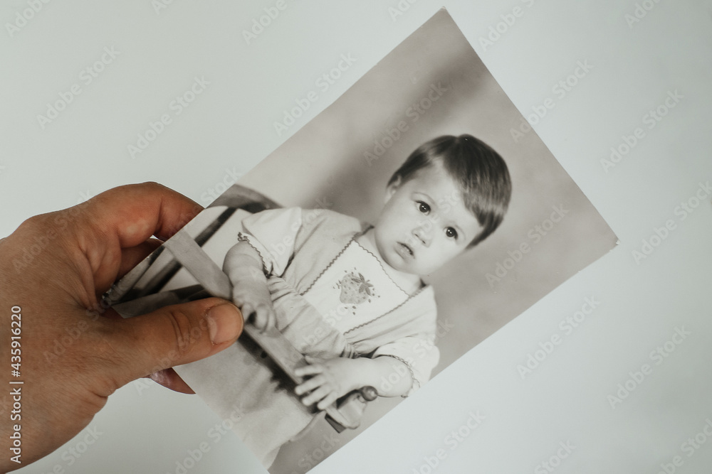 Ivanovo, Russia, May 26, 2021, a child's photo in the hand of an elderly woman, memories Ivanovo, Russia, May 26, 2021, a child's photo in the hand of an elderly woman, memories