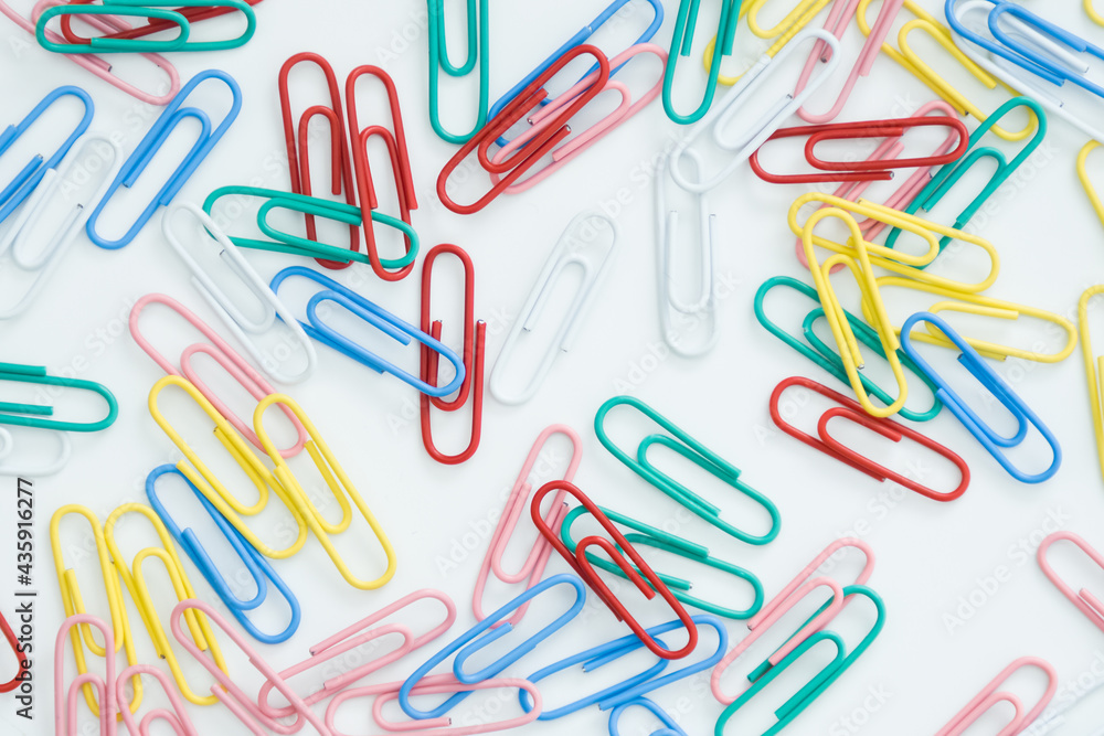 paper clips on a white background, scattered on the table paper clips on a white background, scattered on the table