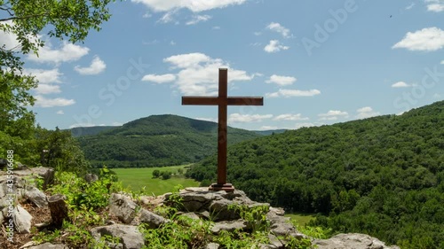 Timelapse of cloud movement over a cross on a hill