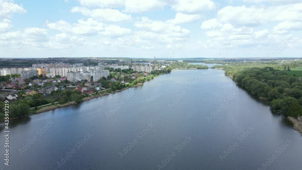 Flight over the river and houses in sunny weather with clouds in the sky Flight over the river and houses in sunny weather with clouds in the sky