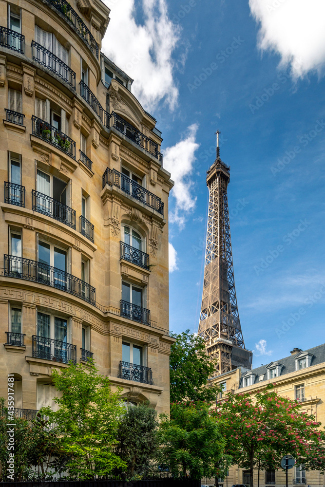 Paris, France - May 10, 2021: Cozy street with view of Eiffel Tower in Paris. Eiffel Tower is one of the most iconic landmarks